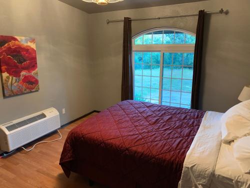 a bedroom with a bed and a window at Mountain Trail Lodge and Vacation Rentals in Oakhurst