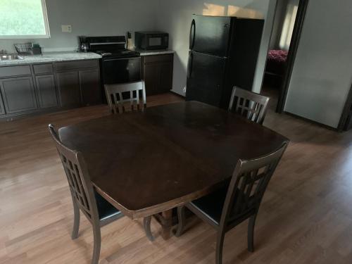 a kitchen with a table and chairs and a black refrigerator at Mountain Trail Lodge and Vacation Rentals in Oakhurst