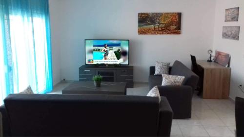 Seaside Villa for 6 people - Alykes Beach في Dhimínion: غرفة معيشة مع أريكة وتلفزيون