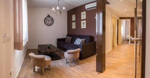 a living room with a couch and a table at Alda Apartamentos Muralla de Toledo in Toledo