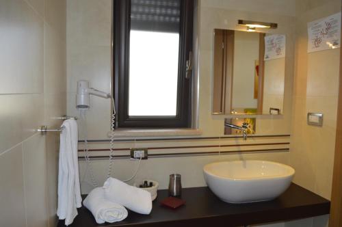 Olo Kalò Locanda في كوريليانو دوترانتو: حمام مزود بحوض ومِرآة