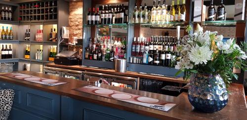 a bar with a vase of flowers on a counter at The Kings Arms Hotel in Stow on the Wold