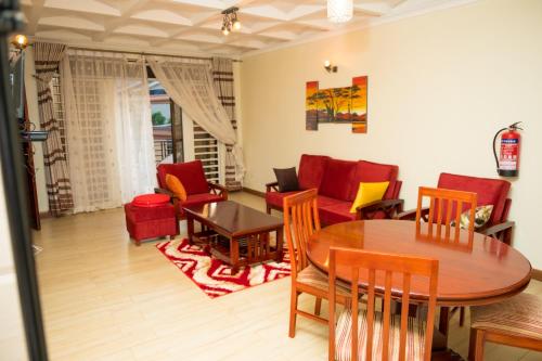 salon ze stołem i krzesłami w obiekcie Kampala Suburbs Apartment w mieście Kampala