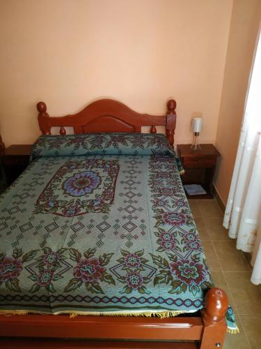 a bedroom with a bed with a quilt on it at El Balcón de Sumaj in Maimará