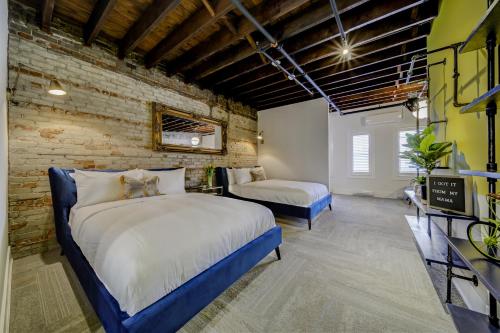 a bedroom with two beds and a brick wall at The Westlake in Toronto