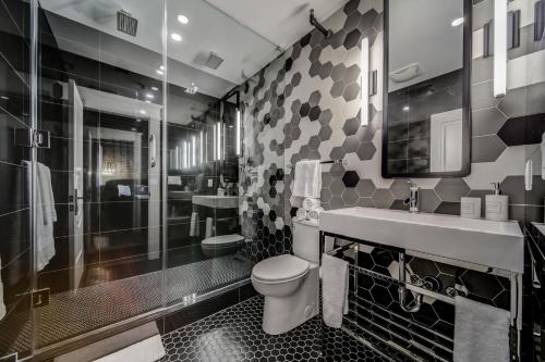 a bathroom with a toilet and a sink and a shower at The Westlake in Toronto