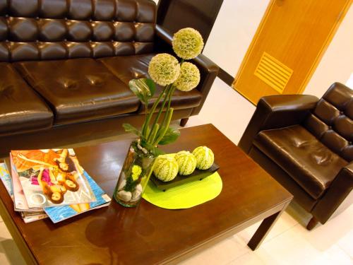 Airport Poddotel Inc. في مانيلا: غرفة معيشة مع طاولة قهوة مع مزهرية مع الزهور