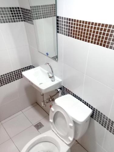 a bathroom with a toilet and a sink at Airport Poddotel Inc. in Manila