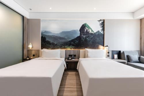 a hotel room with two beds and a couch at Atour Hotel (Tianshui Hige Speed Railway South Xihuang Avenue) in Tianshui
