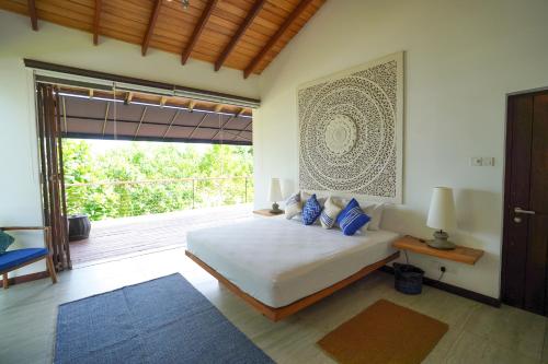 ein Schlafzimmer mit einem Bett und einem großen Fenster in der Unterkunft Solas Surf in Ahangama