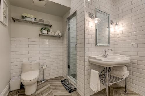 a white bathroom with a toilet and a sink at The Westlake in Toronto