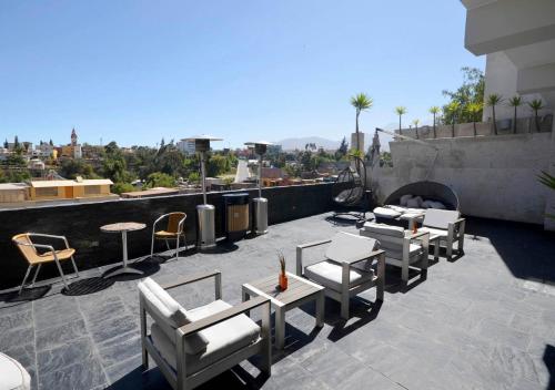 a patio with chairs and tables and a fireplace at qp Hotels Arequipa in Arequipa