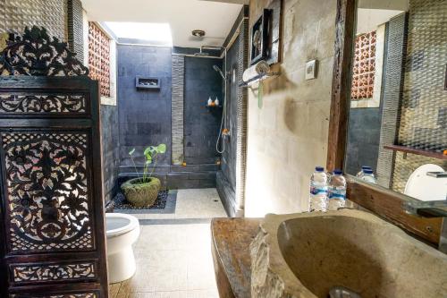 a bathroom with a large sink and a toilet at KTS Balinese Villas in Canggu