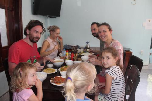 a group of people sitting at a table eating food at Cham Island Smiles Homestay in Tân Hiệp