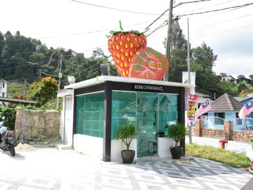 a shop with a giant strawberry on top of it at Darulmakmur Chalet in Cameron Highlands