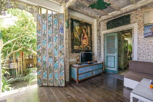 a living room with a couch and a tv on a wall at KTS Balinese Villas in Canggu