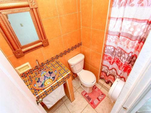 a bathroom with a toilet and a sink and a mirror at Hotel Spa Maggic Home Panorámica in Guanajuato