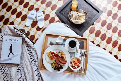 a table with a plate of breakfast food and a book at The Henry Hotel Manila in Manila