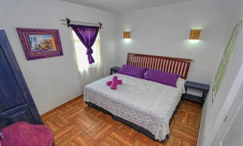 a bedroom with a bed with purple pillows at Hotel Spa Maggic Home Panorámica in Guanajuato