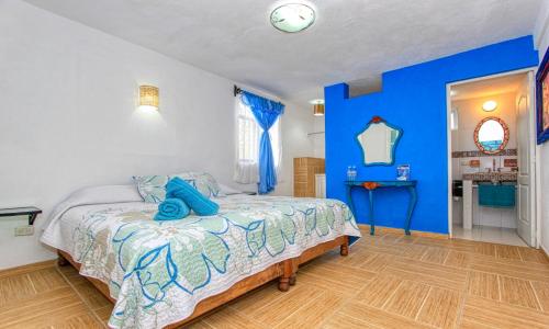 a bedroom with blue walls and a bed with blue pillows at Hotel Spa Maggic Home Panorámica in Guanajuato