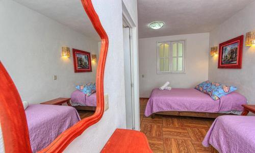 a room with two beds and a mirror at Hotel Spa Maggic Home Panorámica in Guanajuato