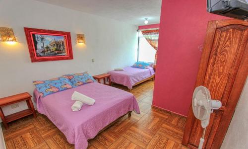 a bedroom with two beds and a fan at Hotel Spa Maggic Home Panorámica in Guanajuato