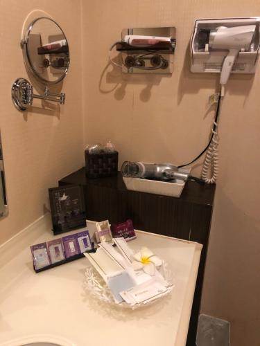 a hospital room with a mirror and a phone at Restay Mito (Adult Only) in Mito