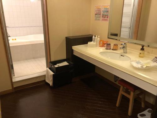 a bathroom with a sink and a tub and a shower at Restay Mito (Adult Only) in Mito
