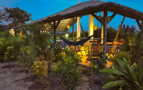 a gazebo with chairs and a hammock at Le Papayer Écolodge in Boukot Ouolof