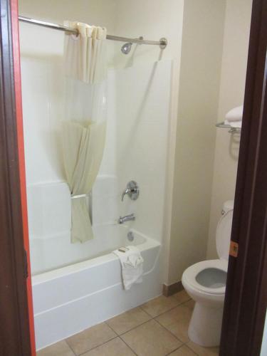 a bathroom with a tub and a toilet at Howard Johnson by Wyndham Lubbock TX in Lubbock