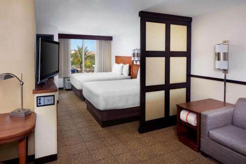 um quarto de hotel com duas camas e uma televisão em Hyatt Place Phoenix/ Mesa em Mesa