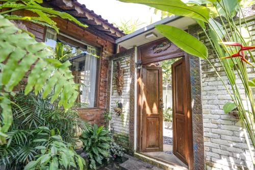 an entrance to a brick house with a wooden door at KTS Balinese Villas in Canggu