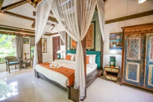 a bedroom with a canopy bed in a room at KTS Balinese Villas in Canggu