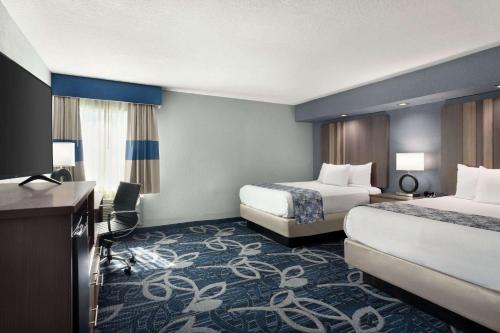 a hotel room with two beds and a television at Baymont Inn & Suites Shawnee in Shawnee