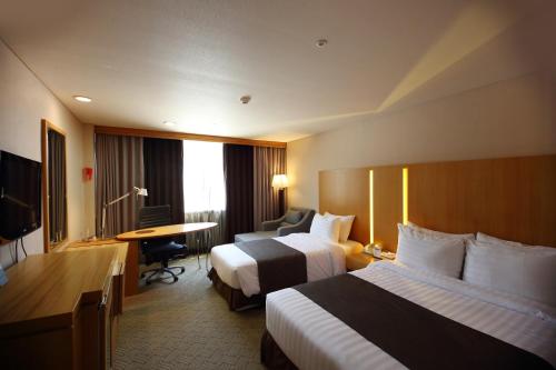 Postel nebo postele na pokoji v ubytování Ramada by Wyndham Songdo