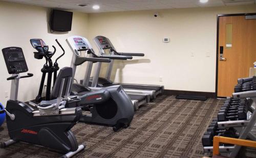 a gym with treadmills and ellipticals in a room at AmericInn by Wyndham Merrill in Merrill