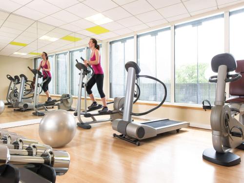 two women exercising on treadmills in a gym at Novotel Mechelen Centrum in Mechelen