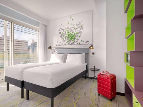 a bedroom with a bed and a red suitcase at Ibis Styles Jerusalem City Center - An AccorHotels Brand in Jerusalem