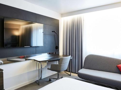 a hotel room with a desk and a couch at Novotel York Centre in York