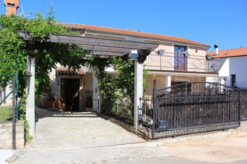 a house with an iron gate and a balcony at Kuca za odmor Luna in Buje