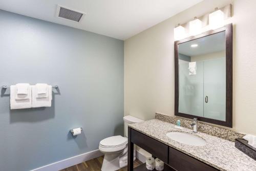 a bathroom with a sink and a toilet and a mirror at MainStay Suites Logan Ohio-Hocking Hills in Logan