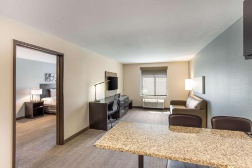 a living room with a room with a bed and a mirror at MainStay Suites Logan Ohio-Hocking Hills in Logan