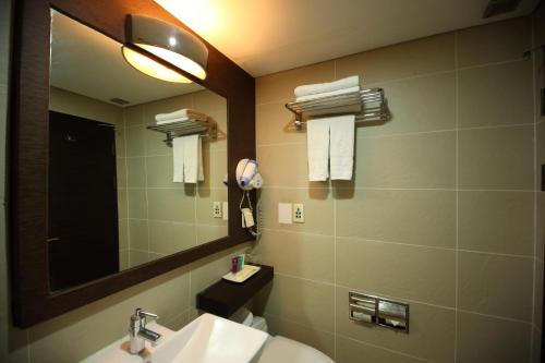 a bathroom with a sink and a mirror at Ramada by Wyndham Songdo in Incheon