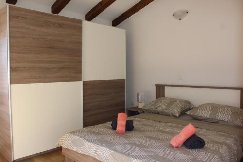 1 dormitorio con 1 cama con almohadas de color naranja en Kuca za odmor Luna, en Buje