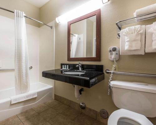 a bathroom with a sink and a toilet and a mirror at Comfort Suites Bakersfield in Bakersfield