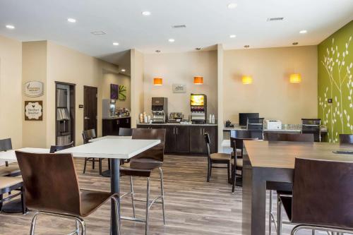 ローガンにあるSleep Inn Logan Ohio-Hocking Hillsのテーブルと椅子のあるレストランとカフェテリア