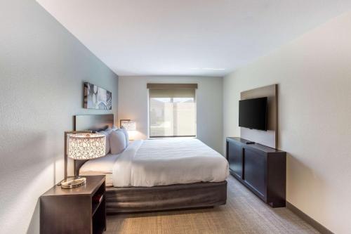 a bedroom with a bed and a flat screen tv at MainStay Suites Logan Ohio-Hocking Hills in Logan