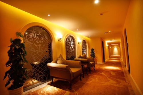 a hallway with chairs and a wall with a door at Aoting Garden Hotel in Chengdu