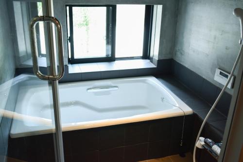 五島的住宿－Okune，带浴缸的浴室和窗户