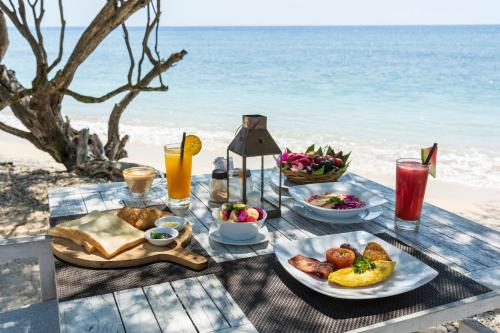 a picnic table with food and drinks on the beach at Gili Eco Villas in Gili Trawangan